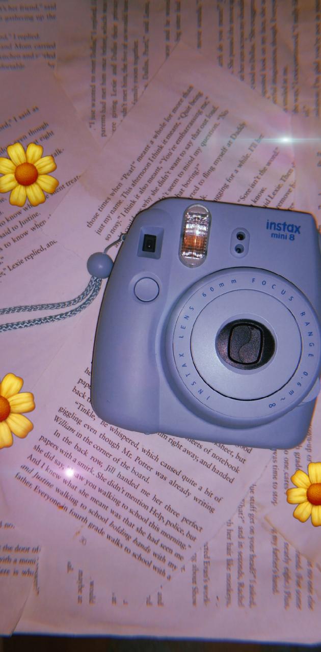 A blue camera on top of a book - Polaroid