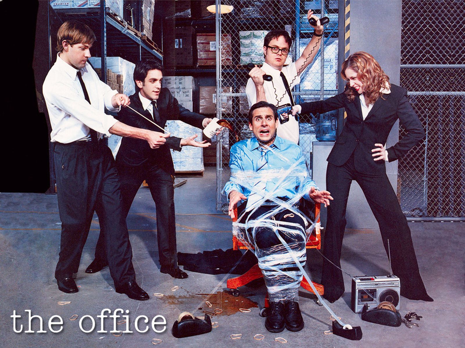 The Office cast members with Michael Scott sitting in a chair wrapped in tape. - The Office
