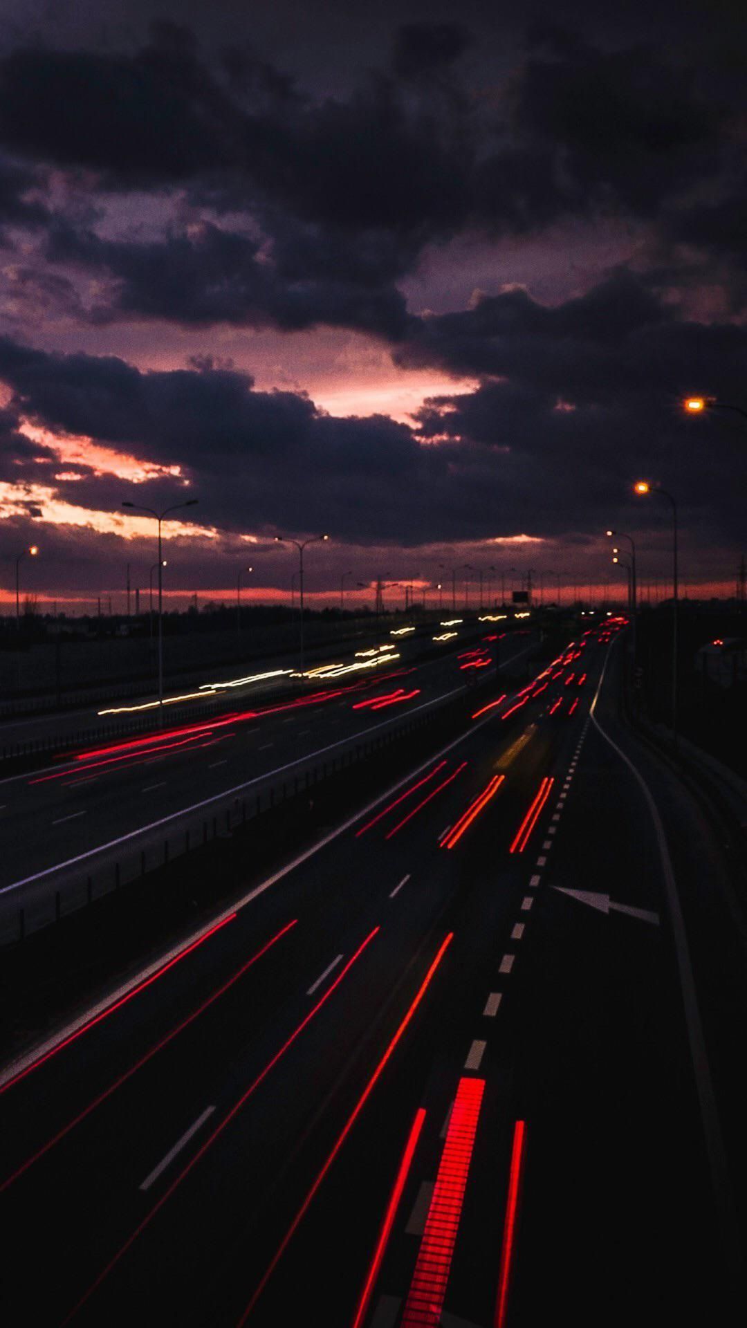 A highway with traffic and lights at night - Road