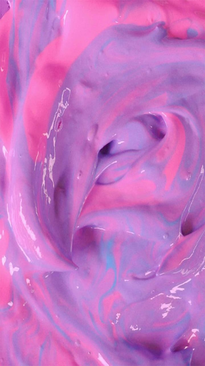 A close up of pink and purple marbled paint - Slime