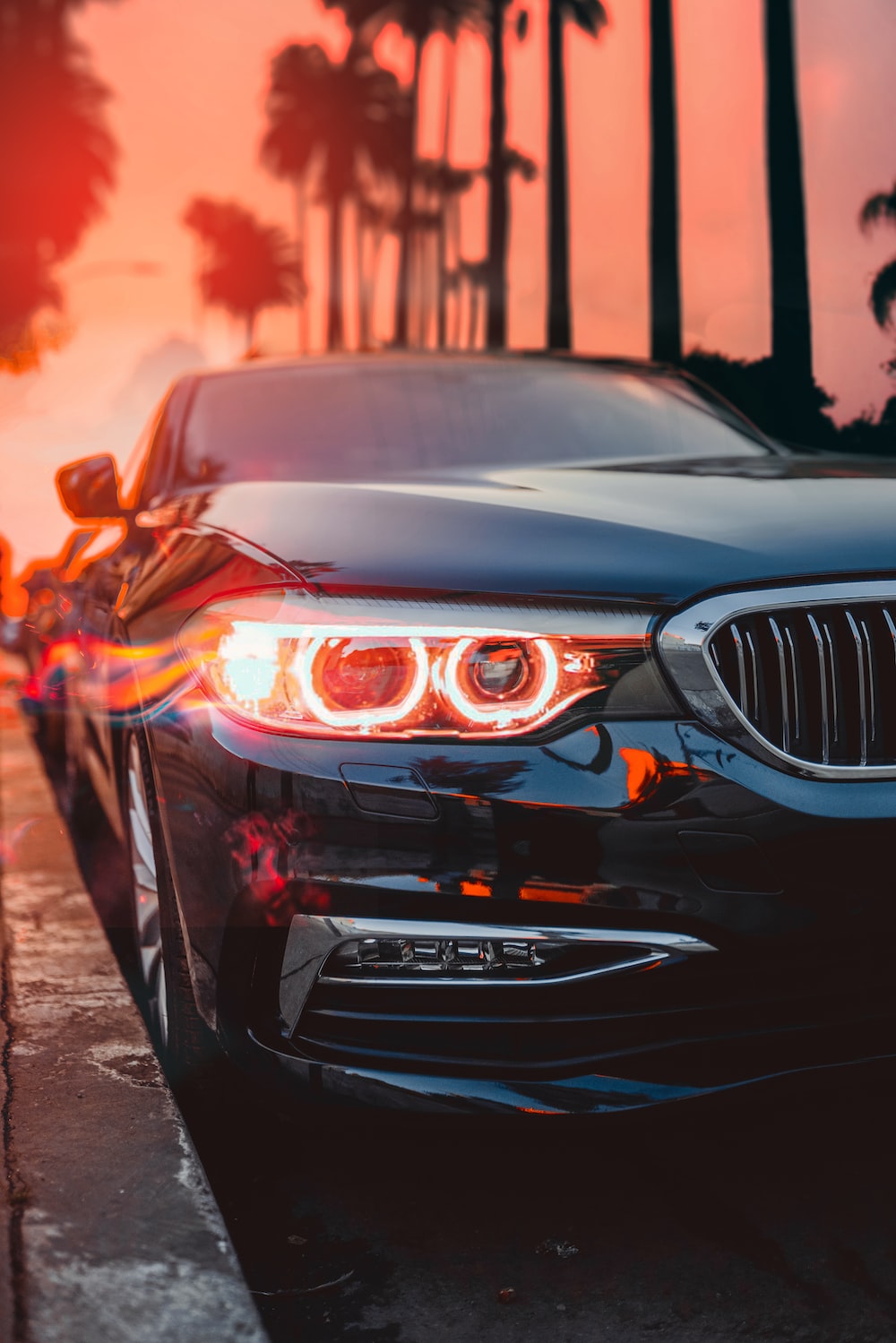 A black car with a headlight on. - BMW