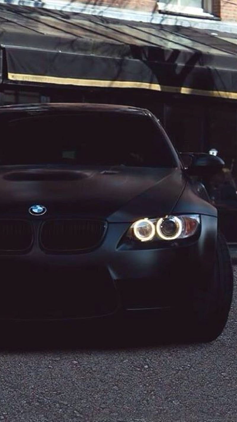 A black BMW is parked in a garage. - BMW