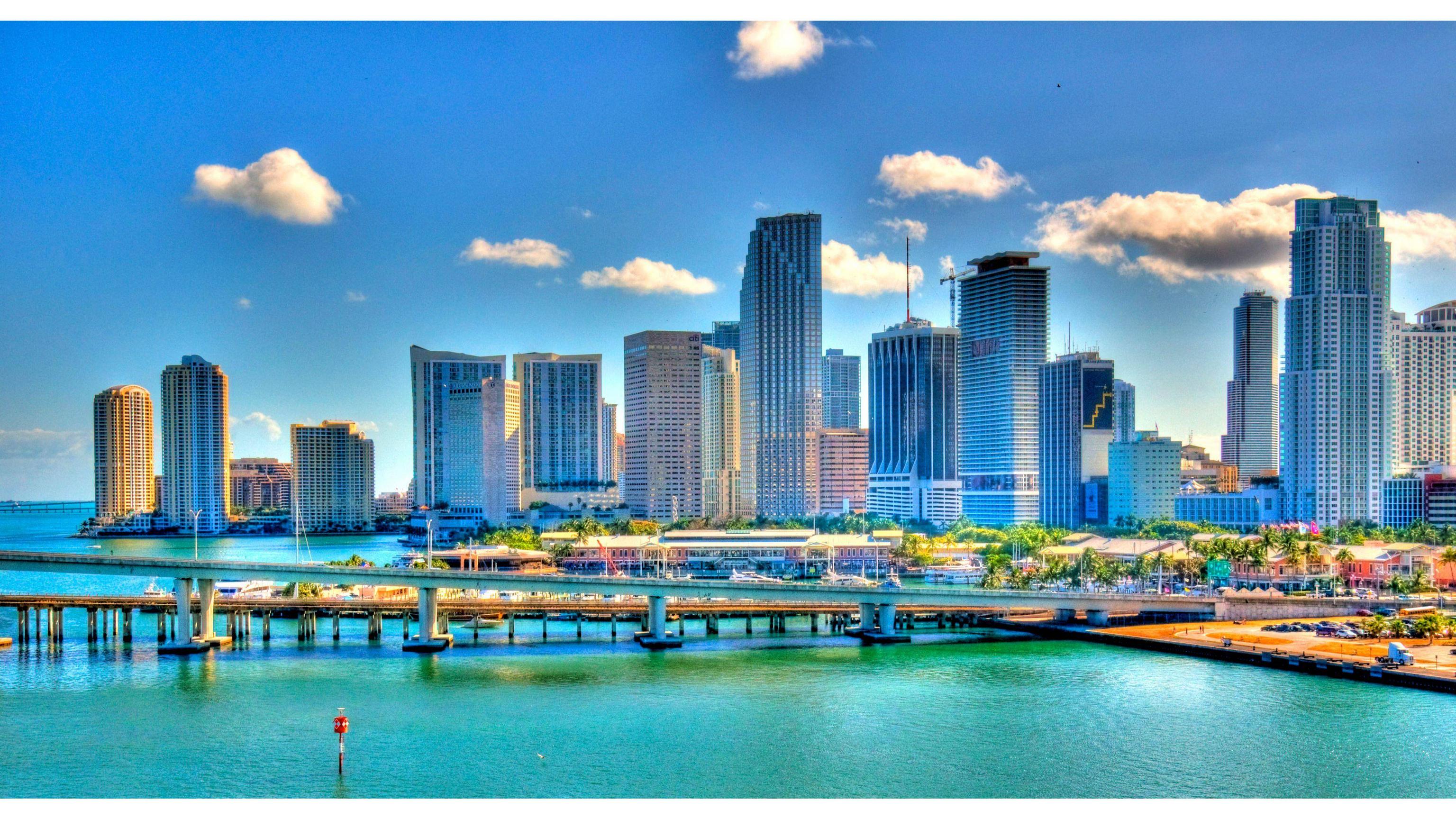 A cityscape of a downtown area with a large body of water in front of it. - Miami