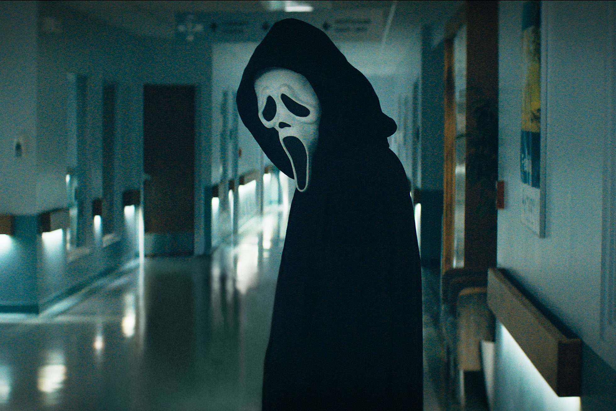 A person in costume standing by the hallway - Ghostface