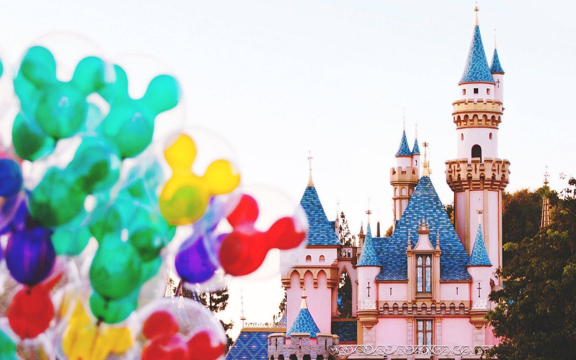 A castle with balloons in front of it - Disneyland