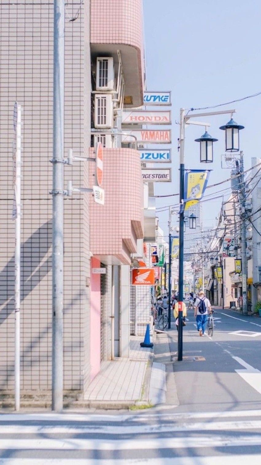 A street corner with a pink building and signs in Japanese. - Seoul