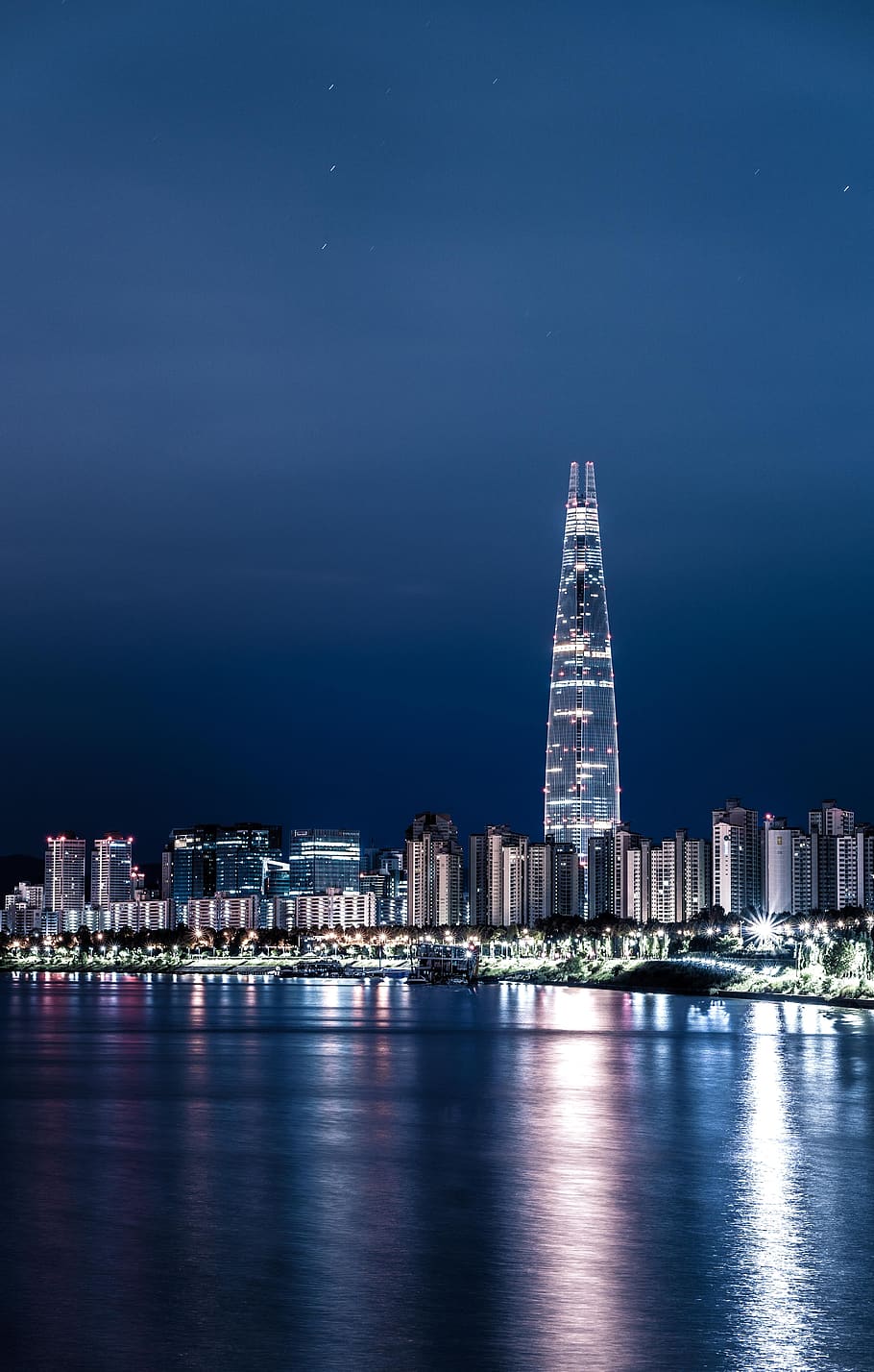 A city skyline at night with the moon in it - Seoul