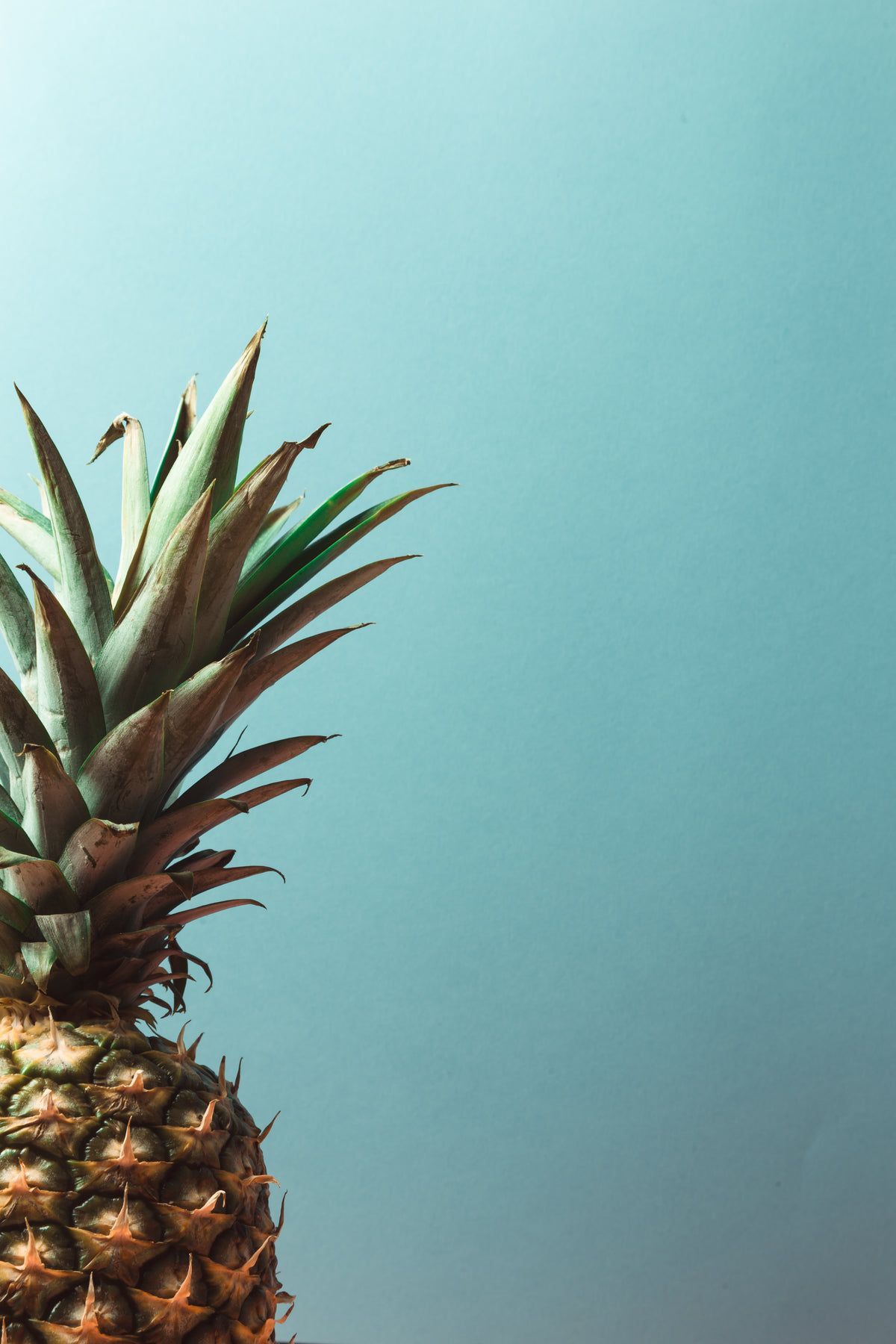 A pineapple sitting on top of some blue paper - Pineapple