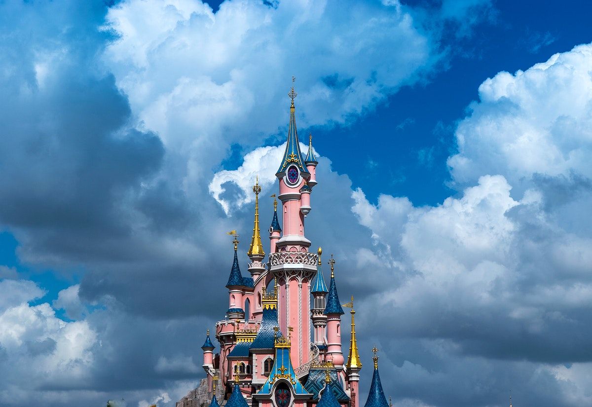 A pink castle with blue and gold towers - Disneyland