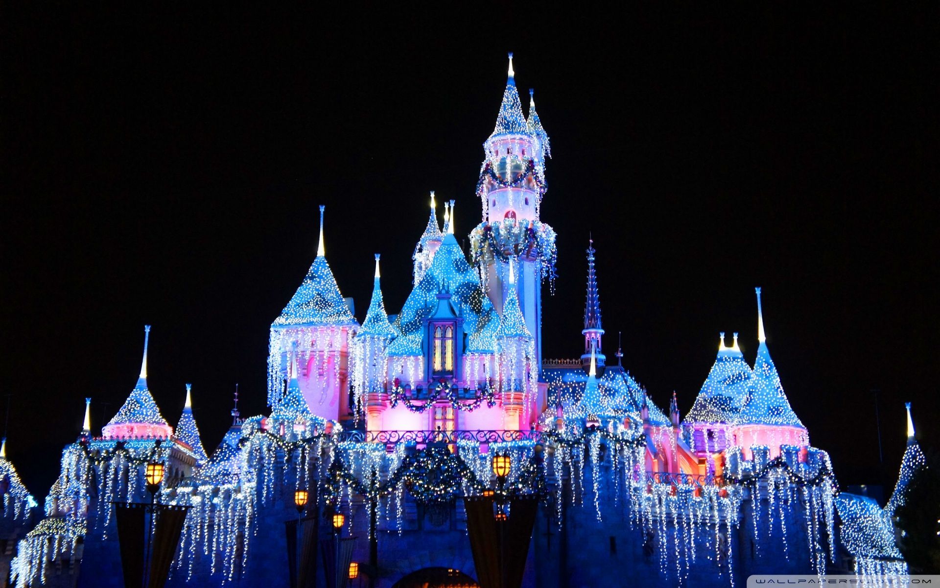 The castle is lit up with Christmas lights. - Disneyland
