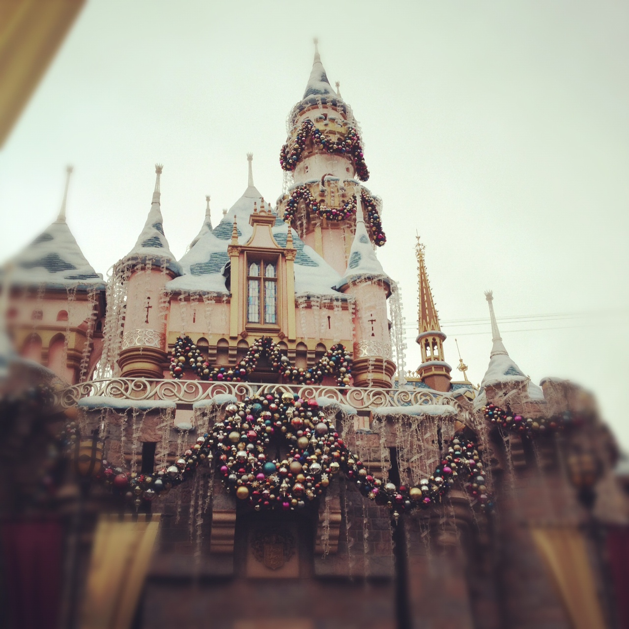 A pink castle with Christmas decorations at Disneyland. - Disneyland