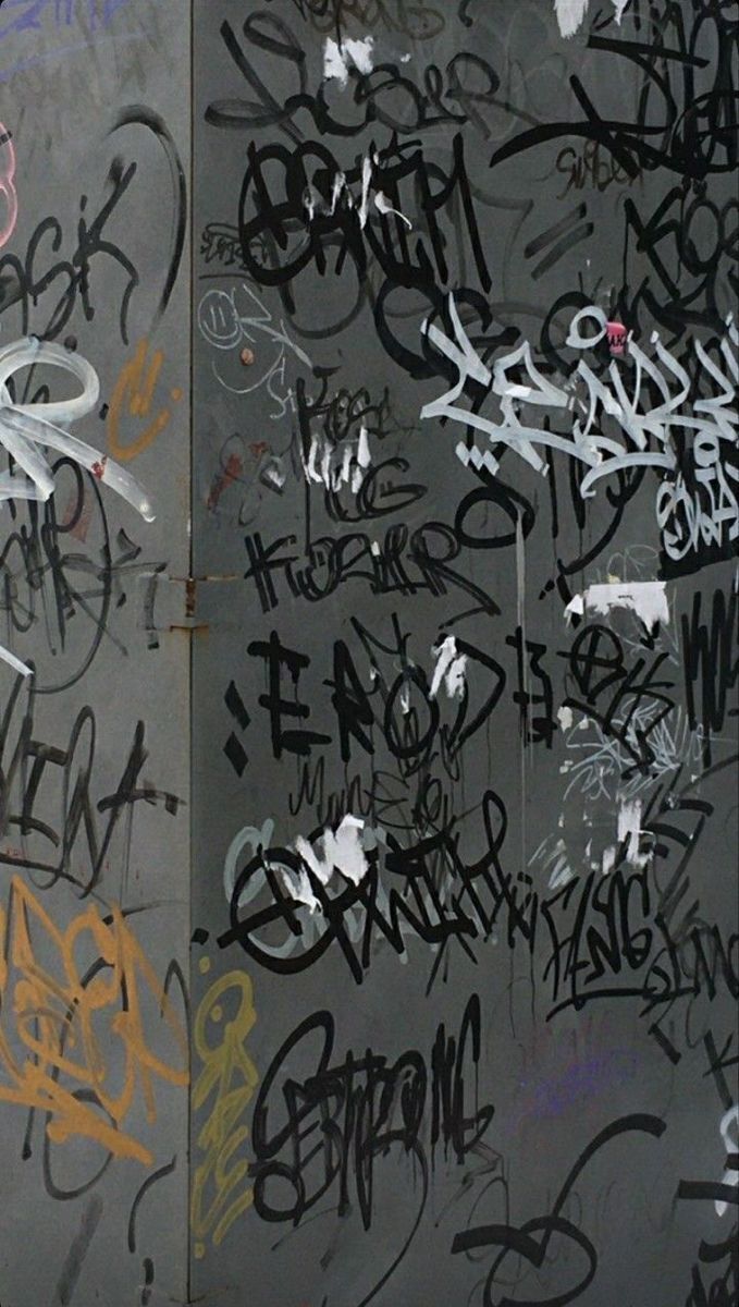 A wall with graffiti on it in the city - Graffiti, street art