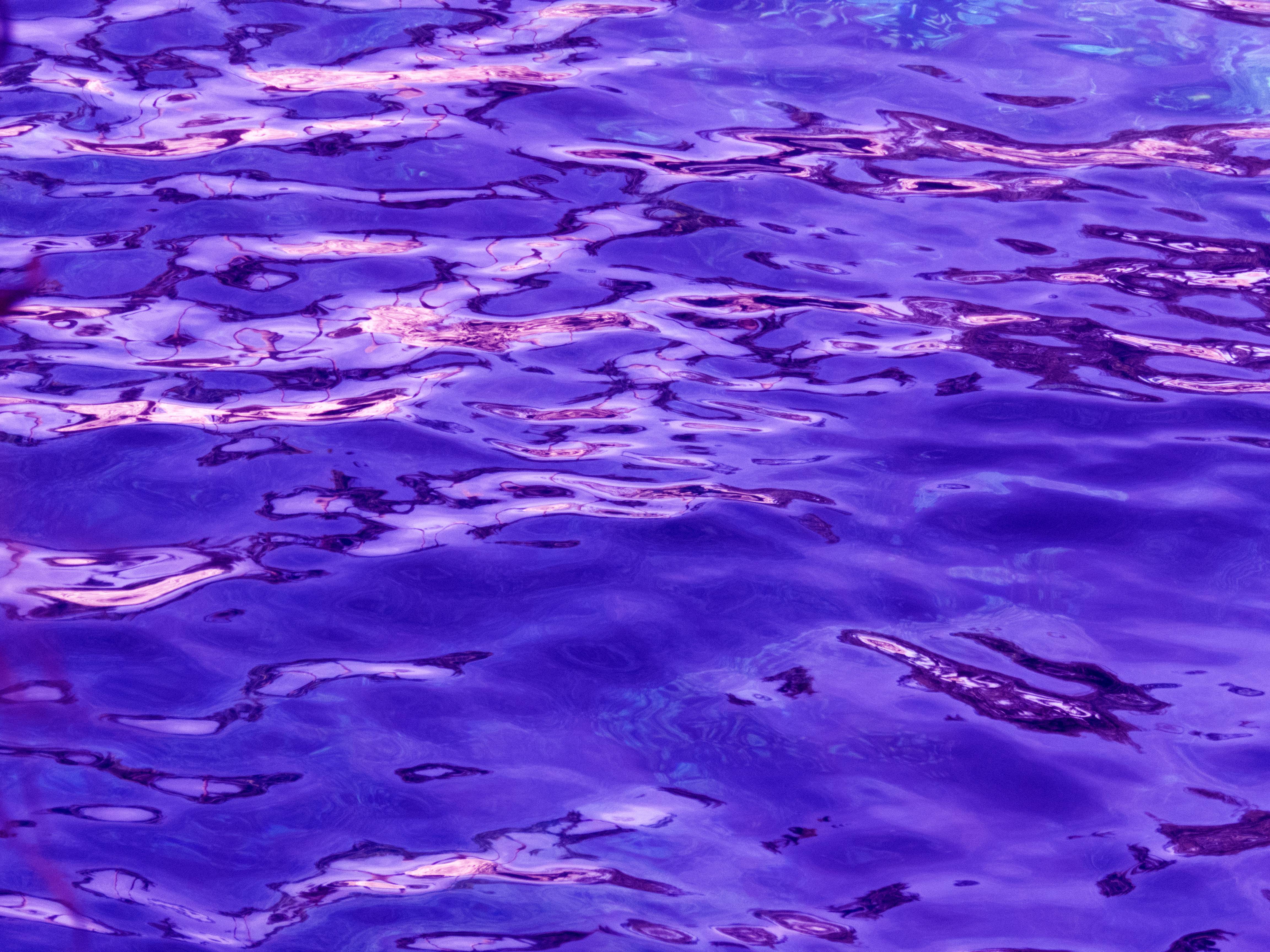 A close up of a pool with a purple hue. - Water