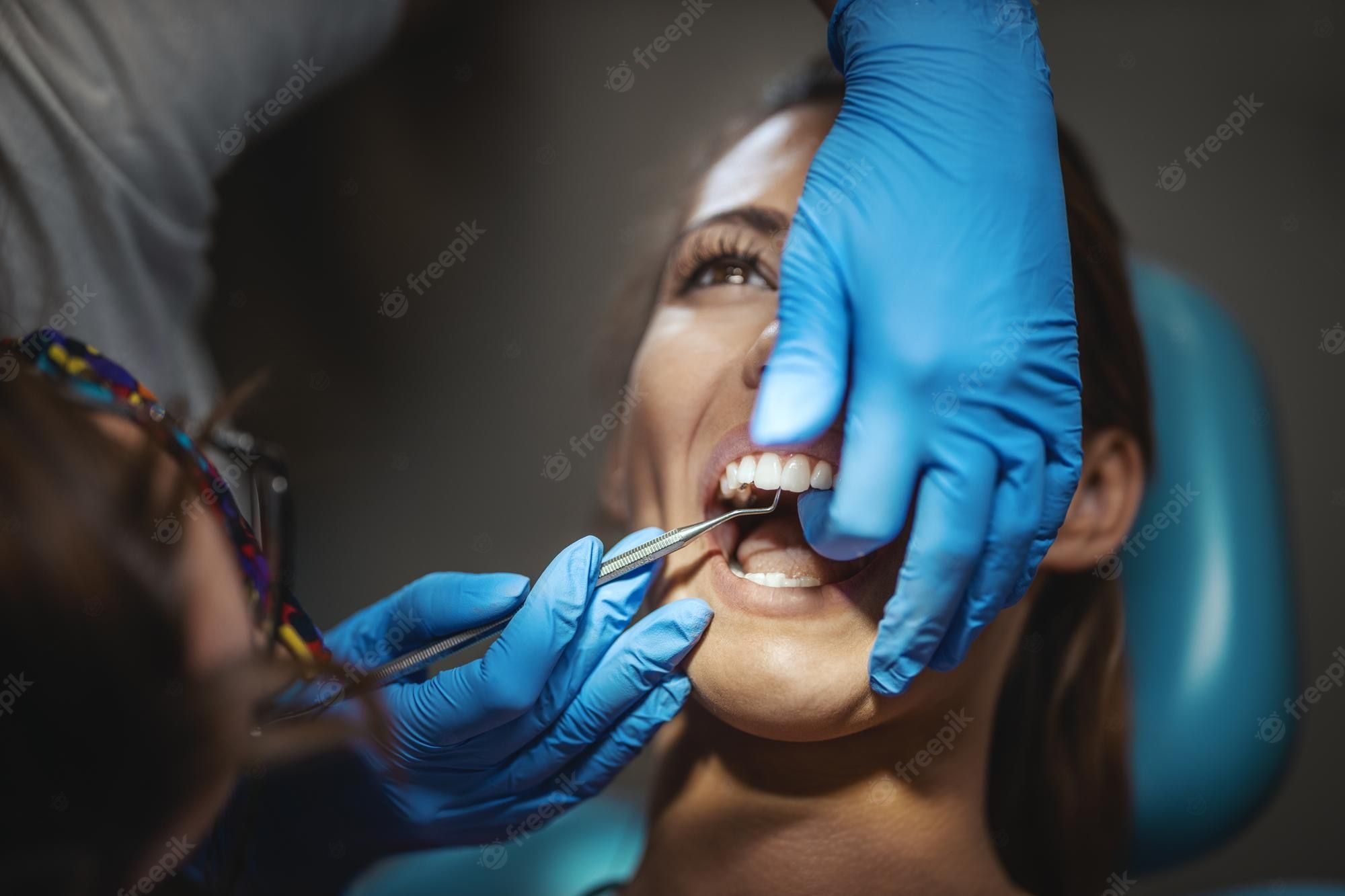 A woman having her teeth checked at the dentist - Dentist