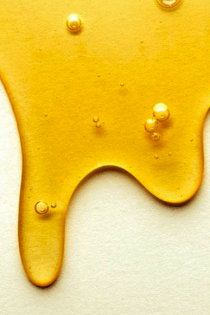 A close up of honey dripping down onto paper - Honey