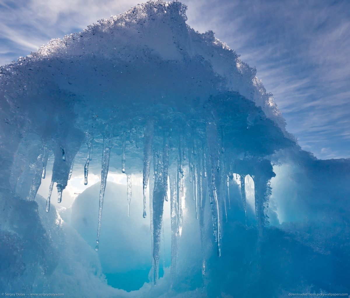 An ice cave with blue light shining through. - Ice