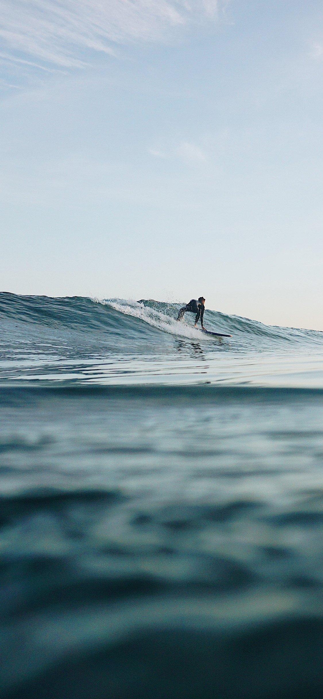 A person on surfboard riding the waves - Surf