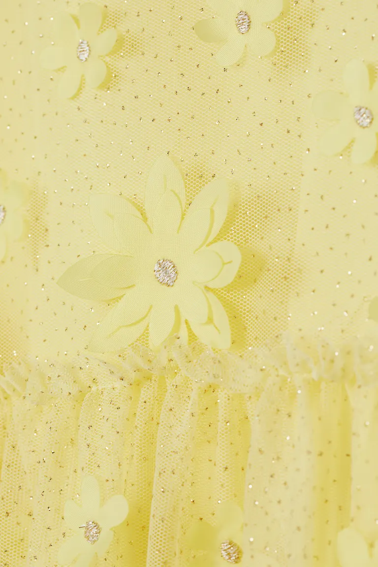 A close up of the yellow tulle dress with flowers and sequins - Light yellow