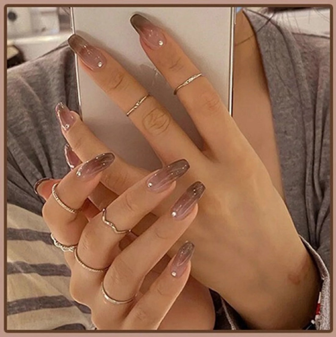 A woman with long nails and rings on her fingers. - Nails
