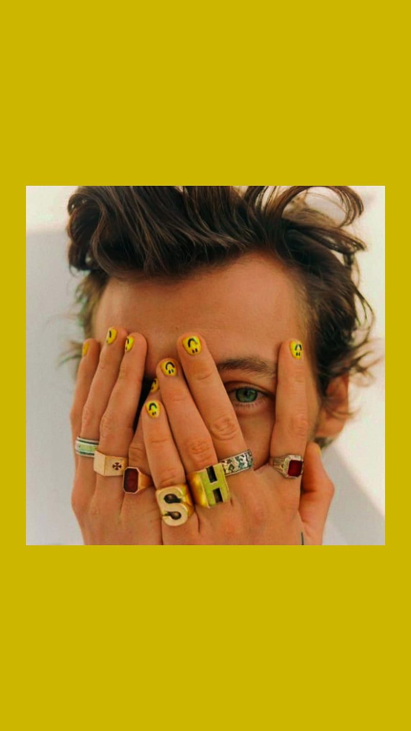 A man with yellow nails covering his face - Nails