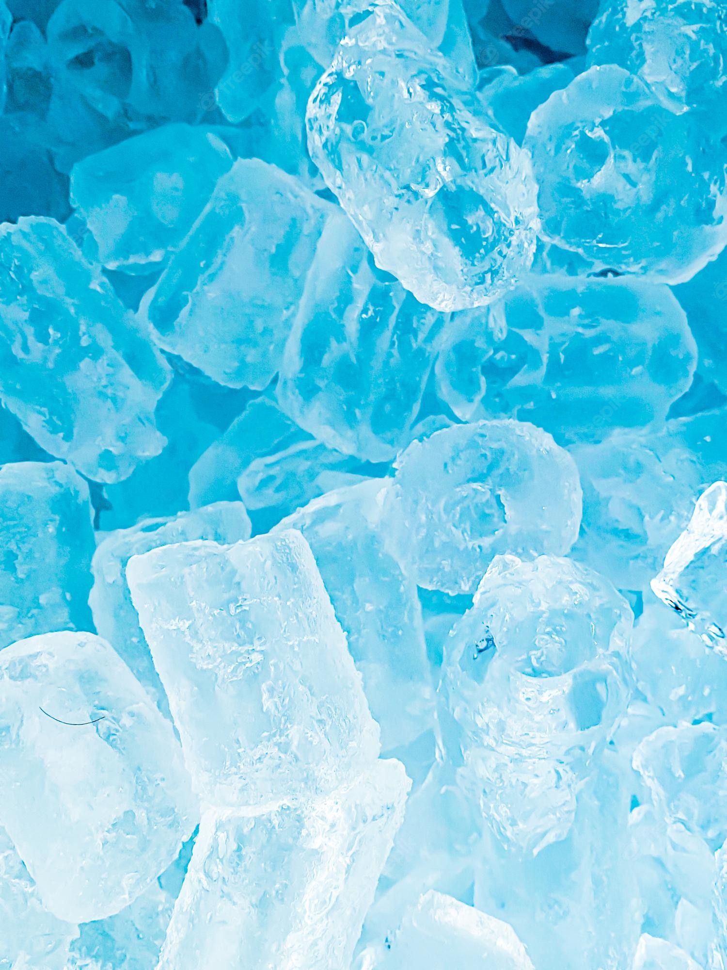 A close up of ice cubes in a blue bin. - Ice