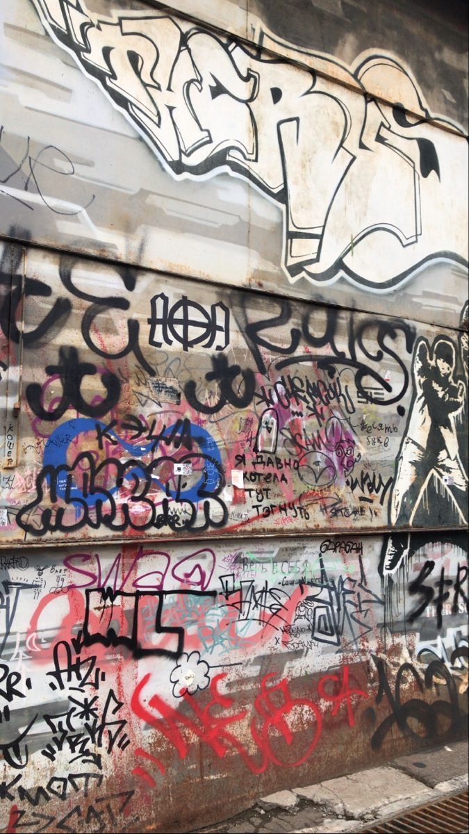 A wall covered in graffiti. - Graffiti, street art