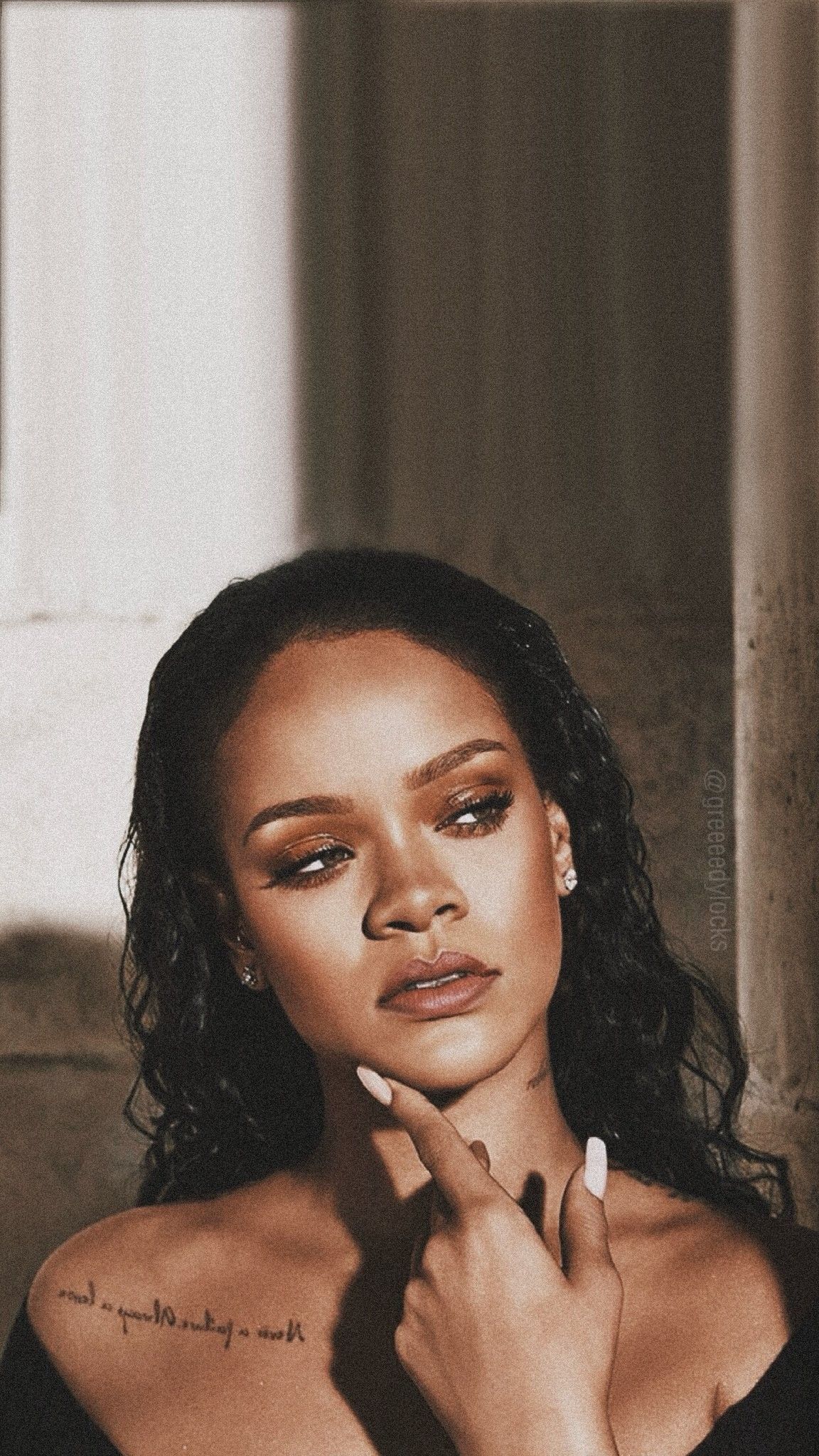 A sepia photo of Rihanna with her hand on her chin - Rihanna