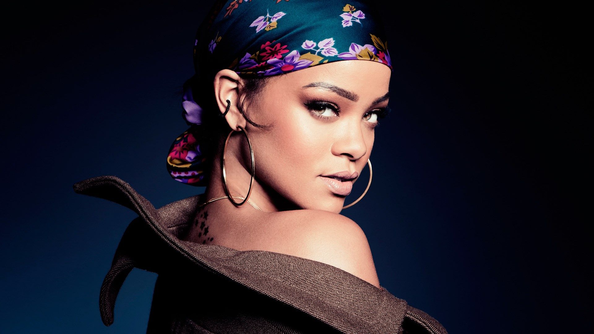 A woman with an earring and headband - Rihanna
