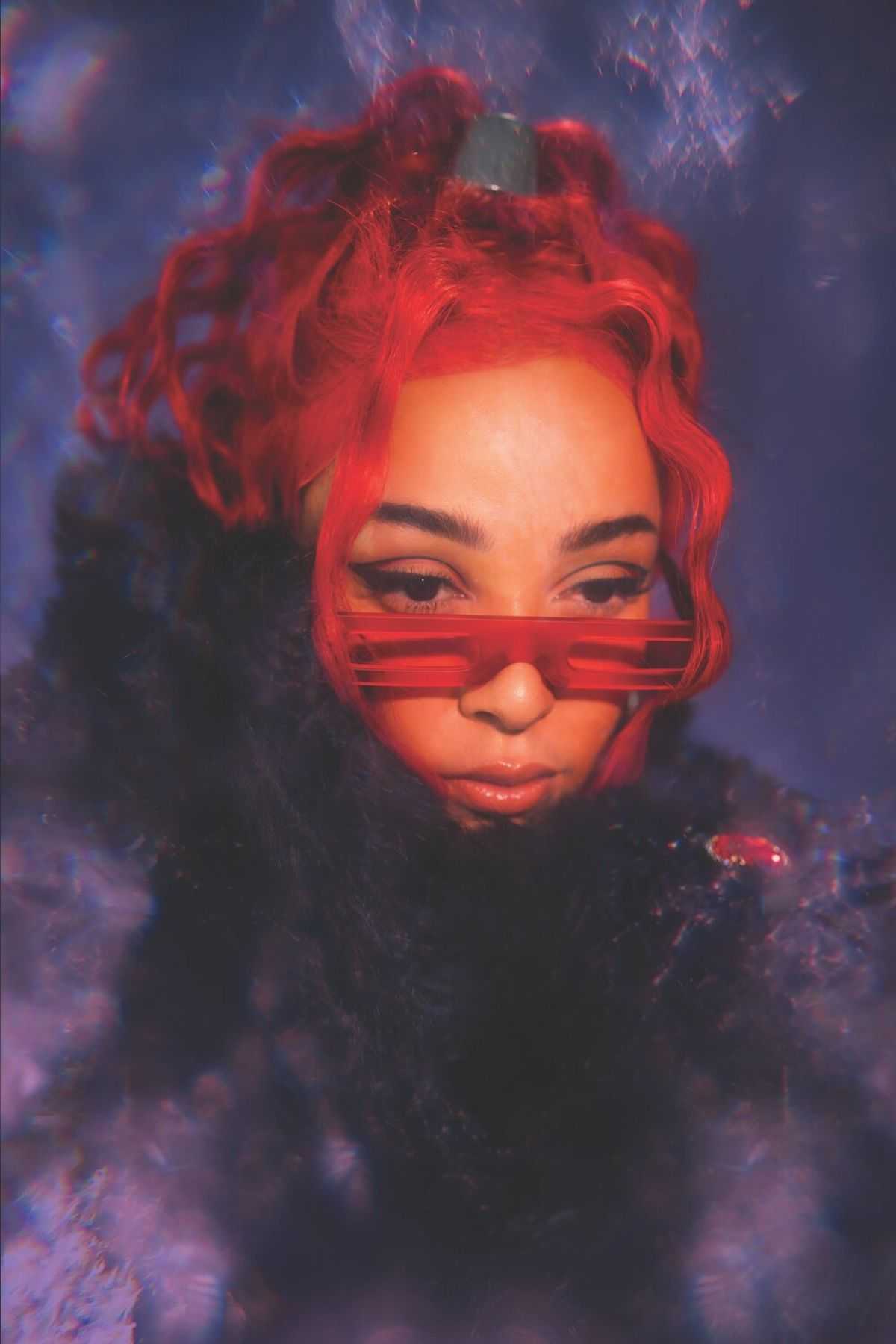 A woman with red hair and red sunglasses. - Doja Cat