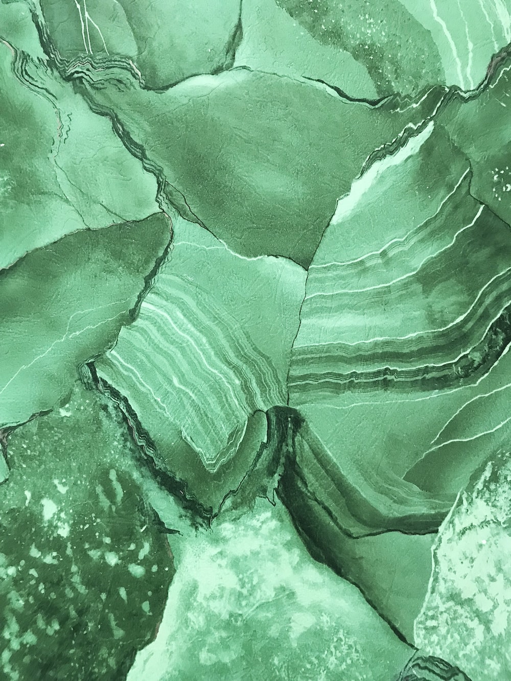 A painting of green rocks on the ground - Lime green, light green, dark green