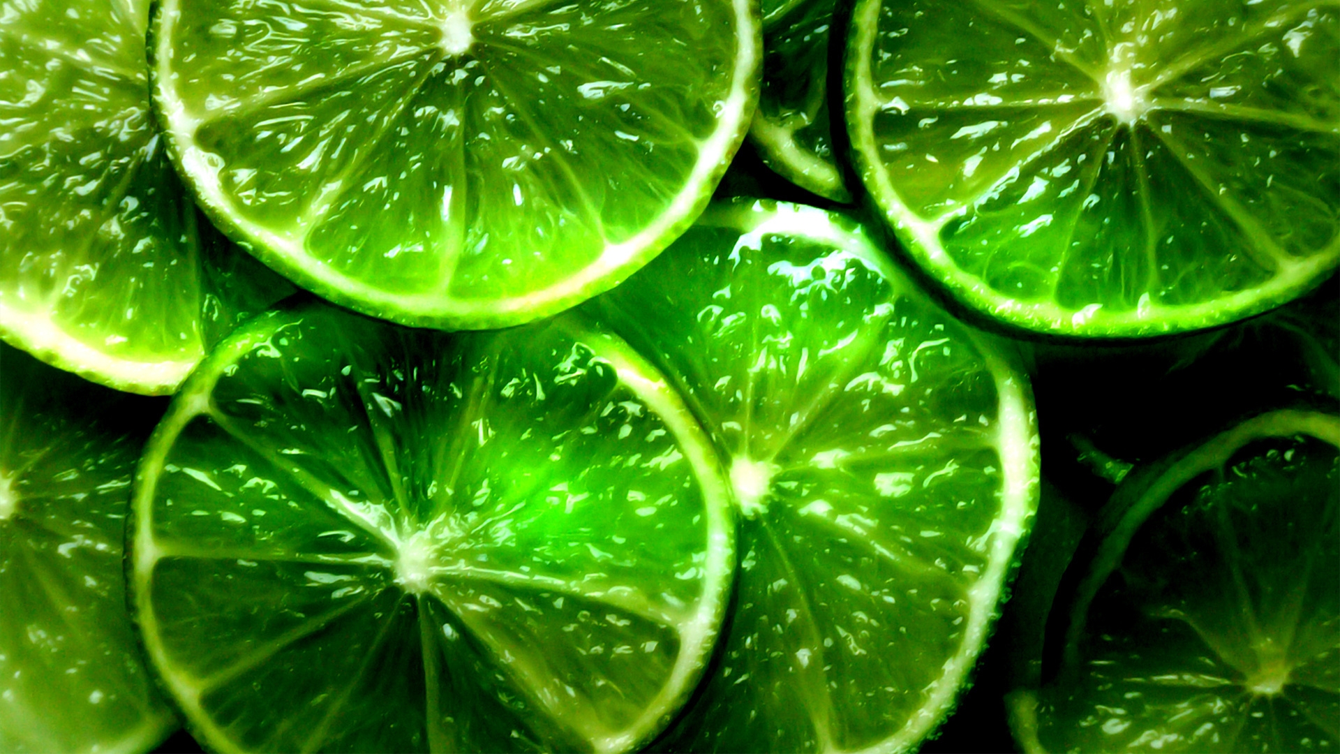 A close up of a pile of sliced limes. - Lime green