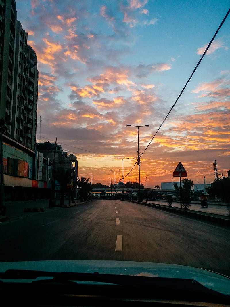 A beautiful sunset over a nearly empty road in a city. - Sunrise