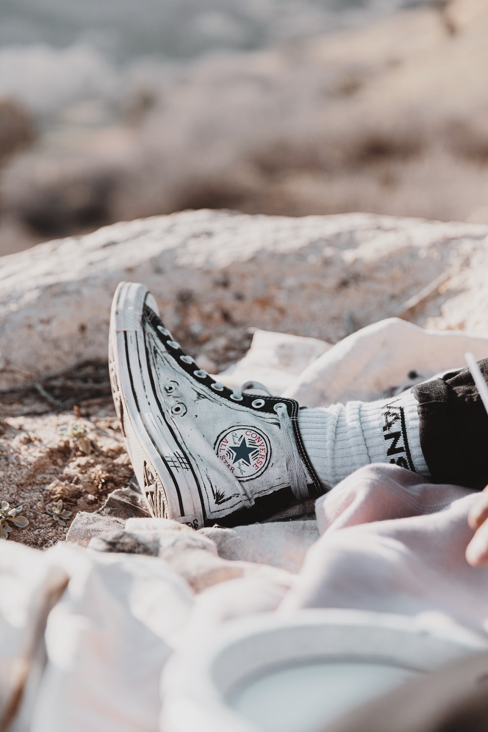 person wearing black and white converse all star high top sneakers photo