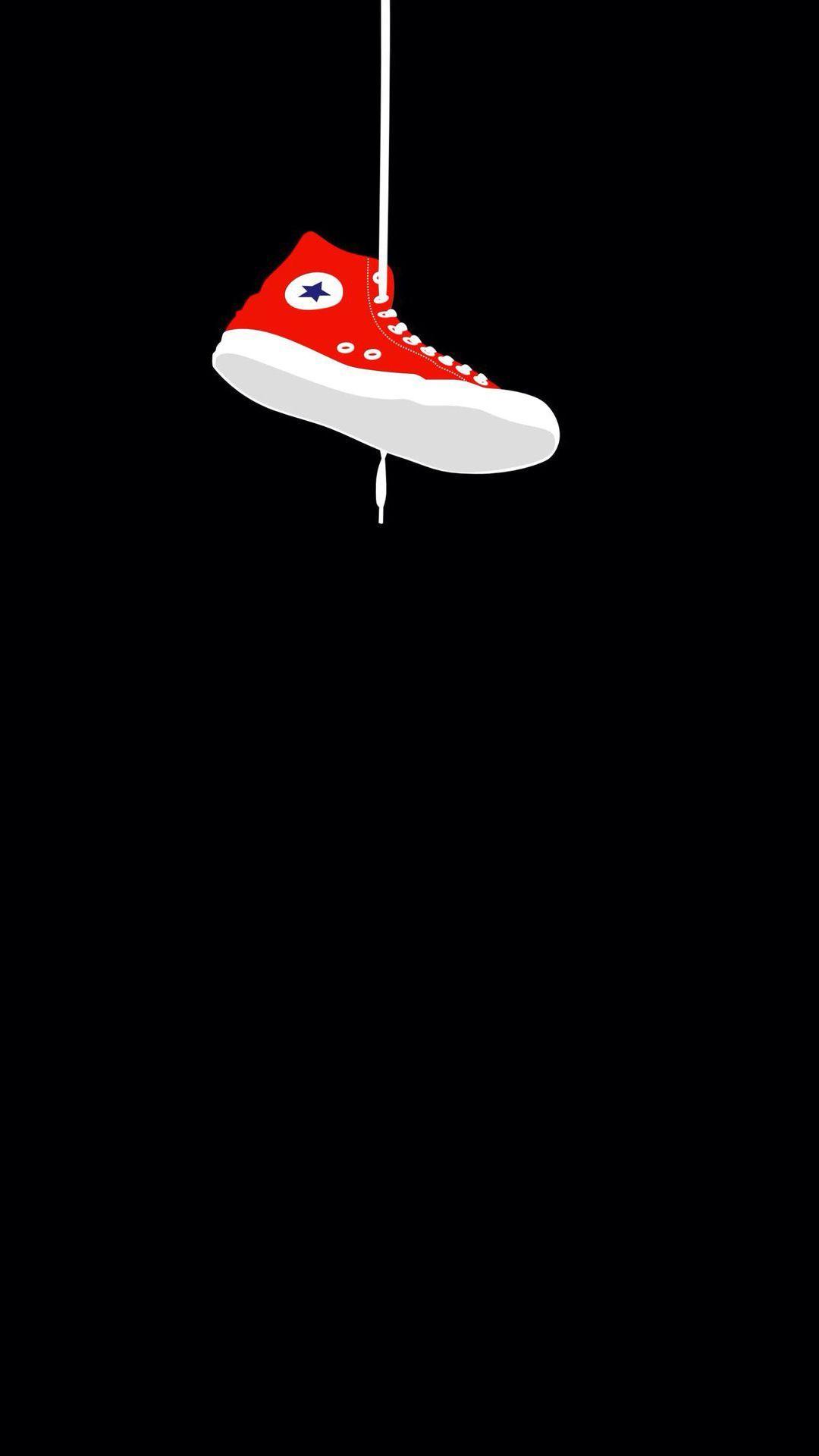 A red and white sneaker hanging from the ceiling - Converse