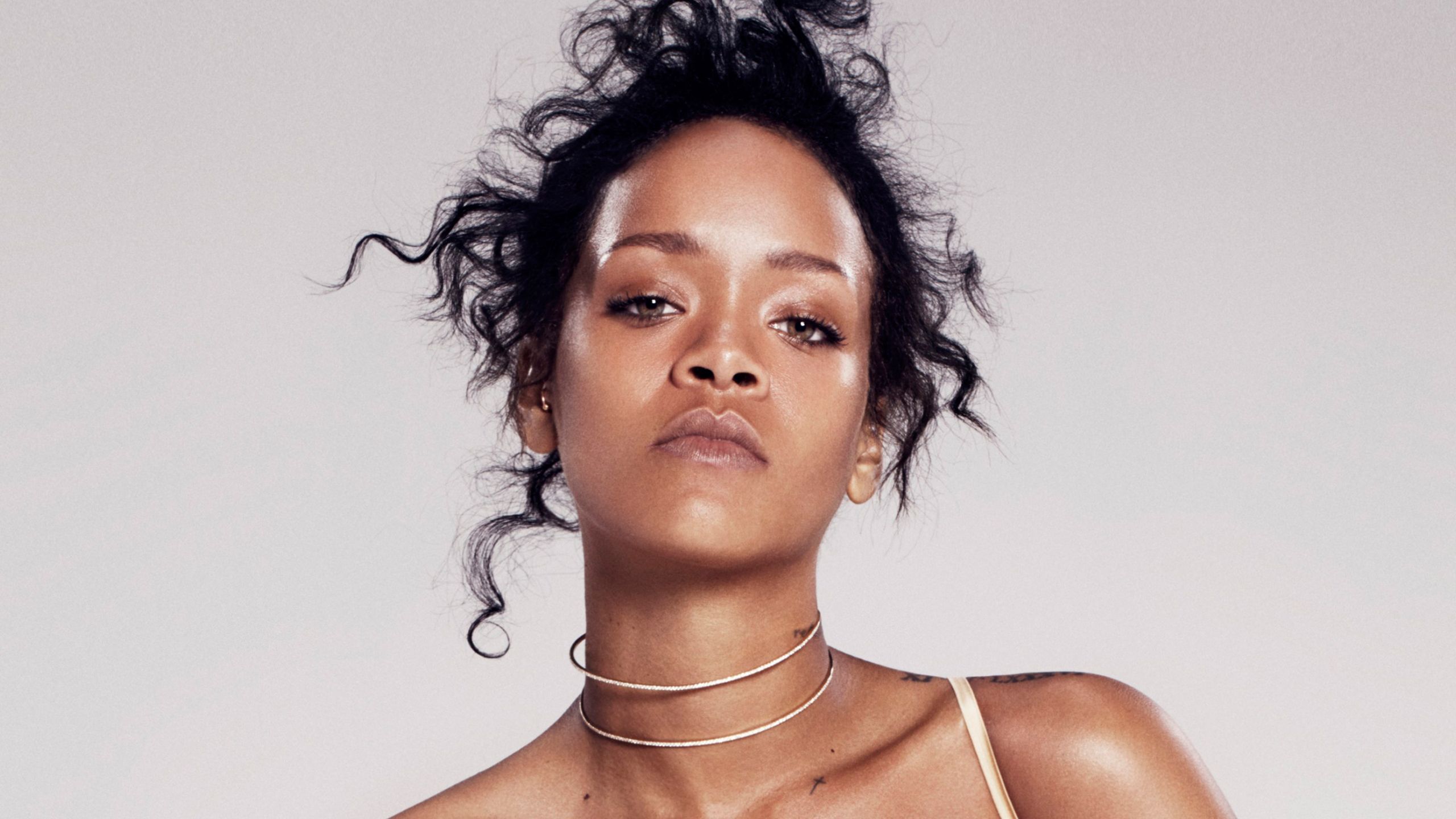 Rihanna in a white bralette with her hair in a messy bun - Rihanna