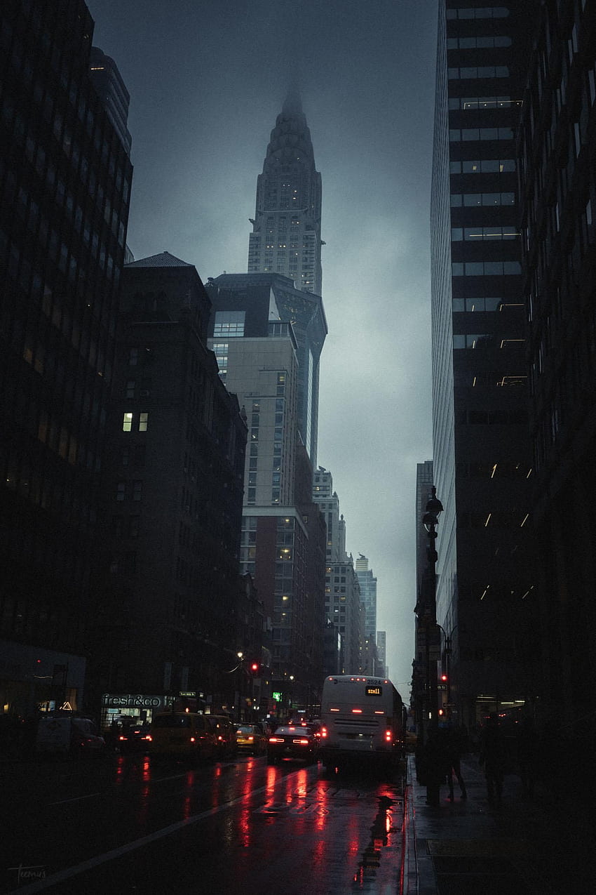 A city street with cars and a bus, and a tall building in the distance. - Rain, New York, city