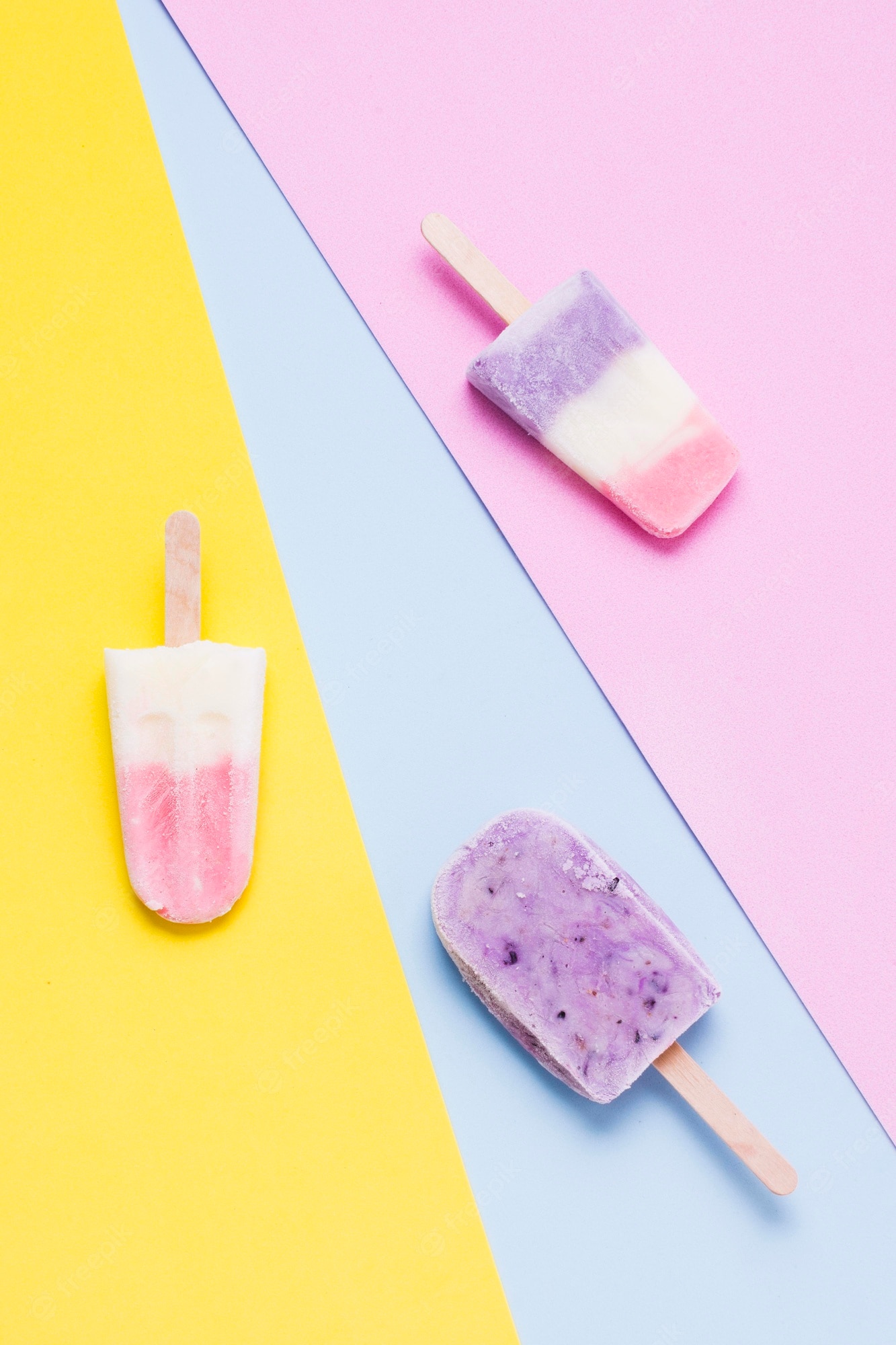 Three popsicles on a yellow, blue, and pink background - Ice cream