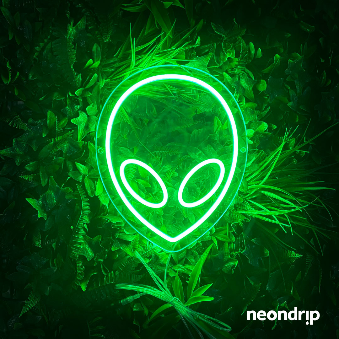 A neon sign of an alien head on a green background with leaves - Neon green