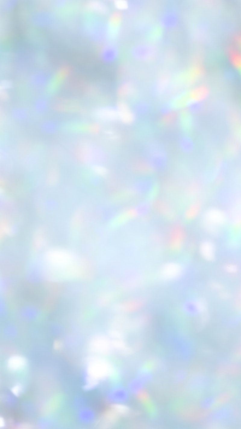 A white and blue background with rainbow light streaks - Glitter, blurry