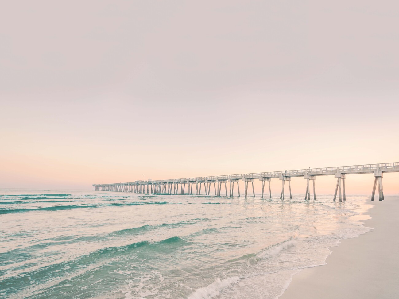 A beach with a pier and the ocean - Florida