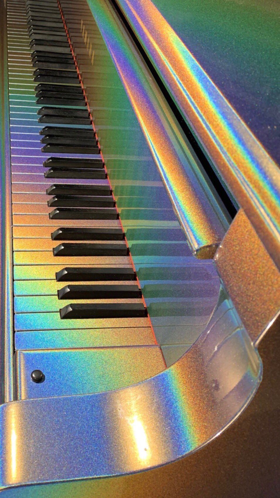 A close up of a piano with a rainbow colored top. - Piano