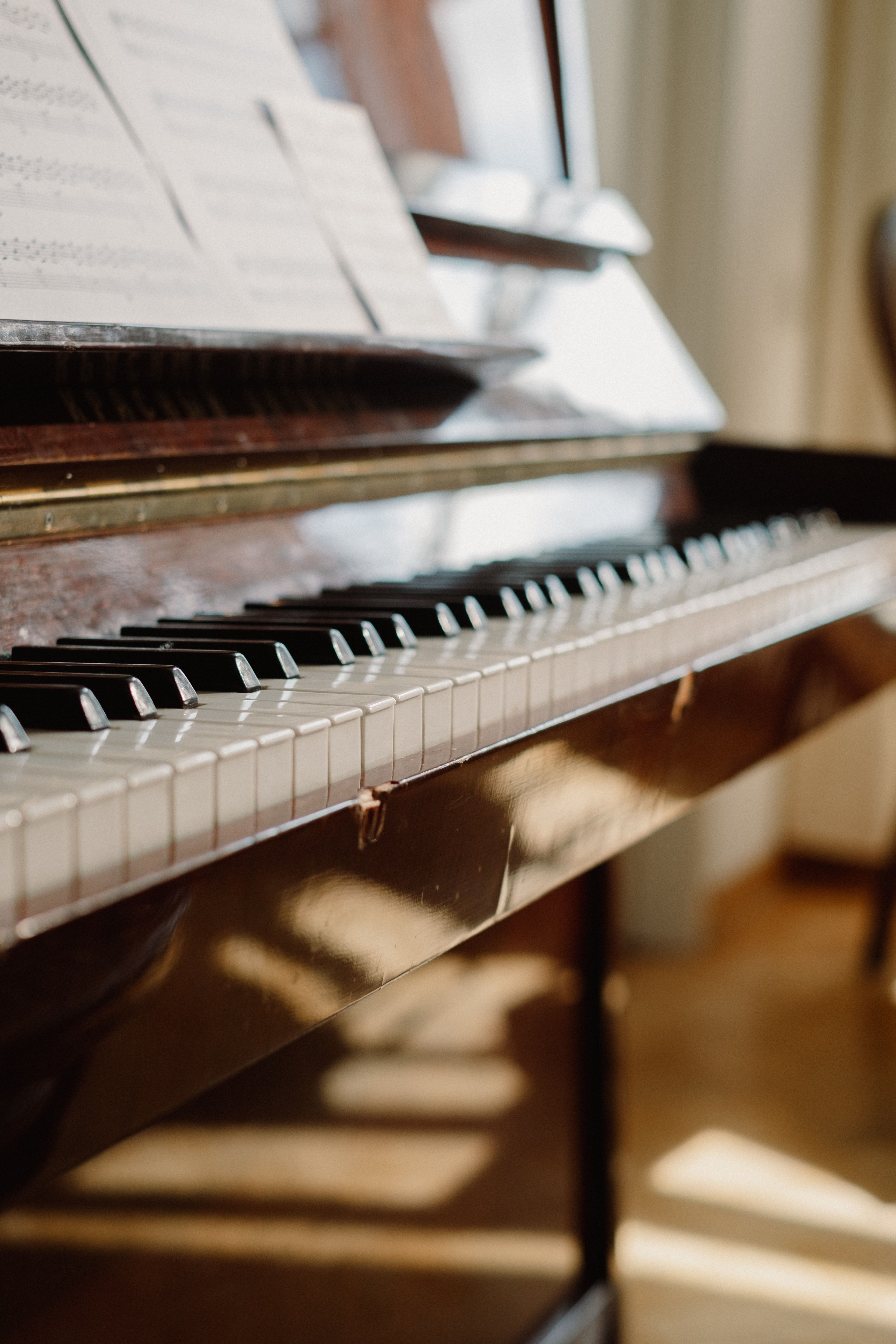 A close up of a piano with sheet music on top. - Piano