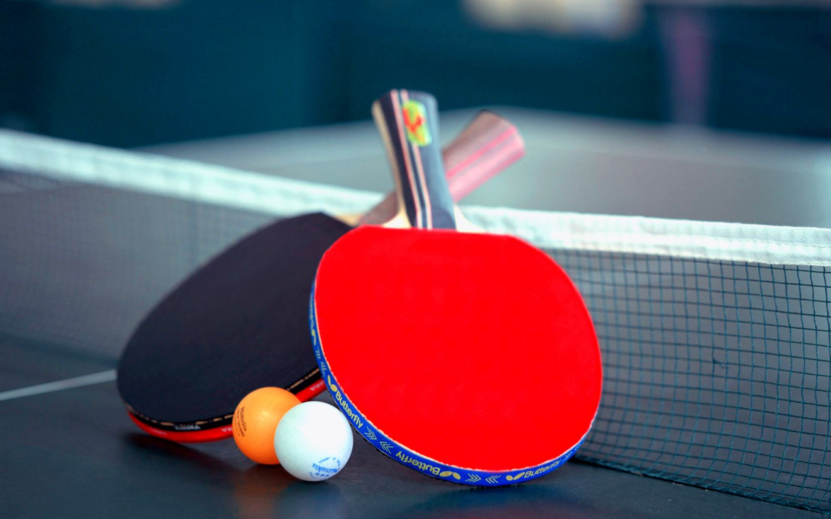 Two ping pong paddles and balls on a ping pong table - Tennis