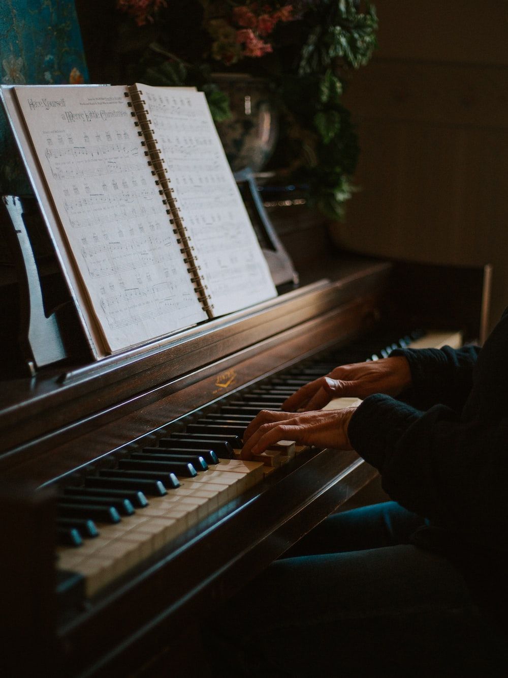 A person playing the piano with sheet music. - Piano