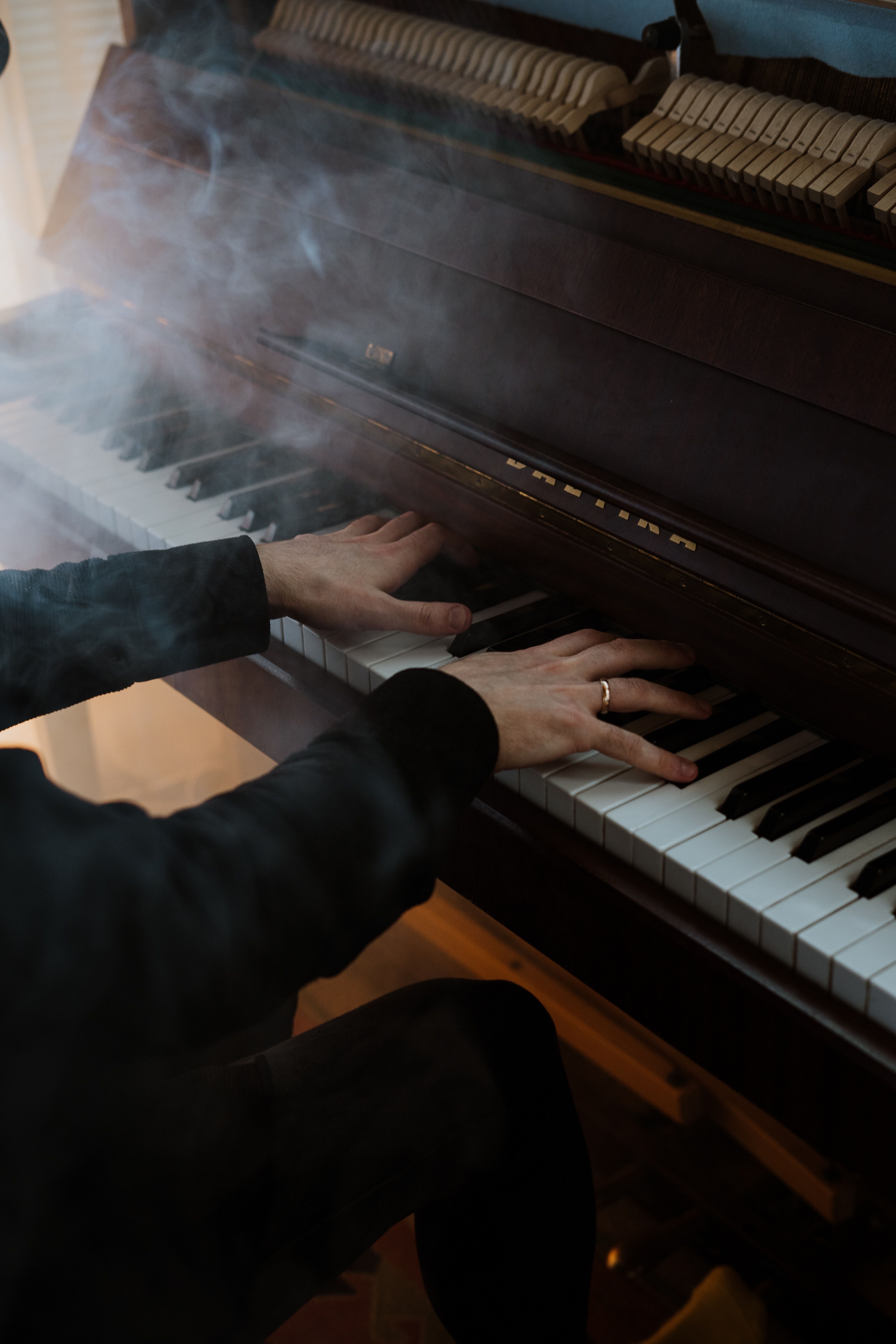 A person playing the piano in front of smoke - Piano