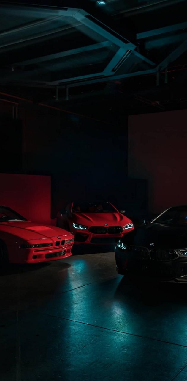 Three BMW cars in a dark room - BMW