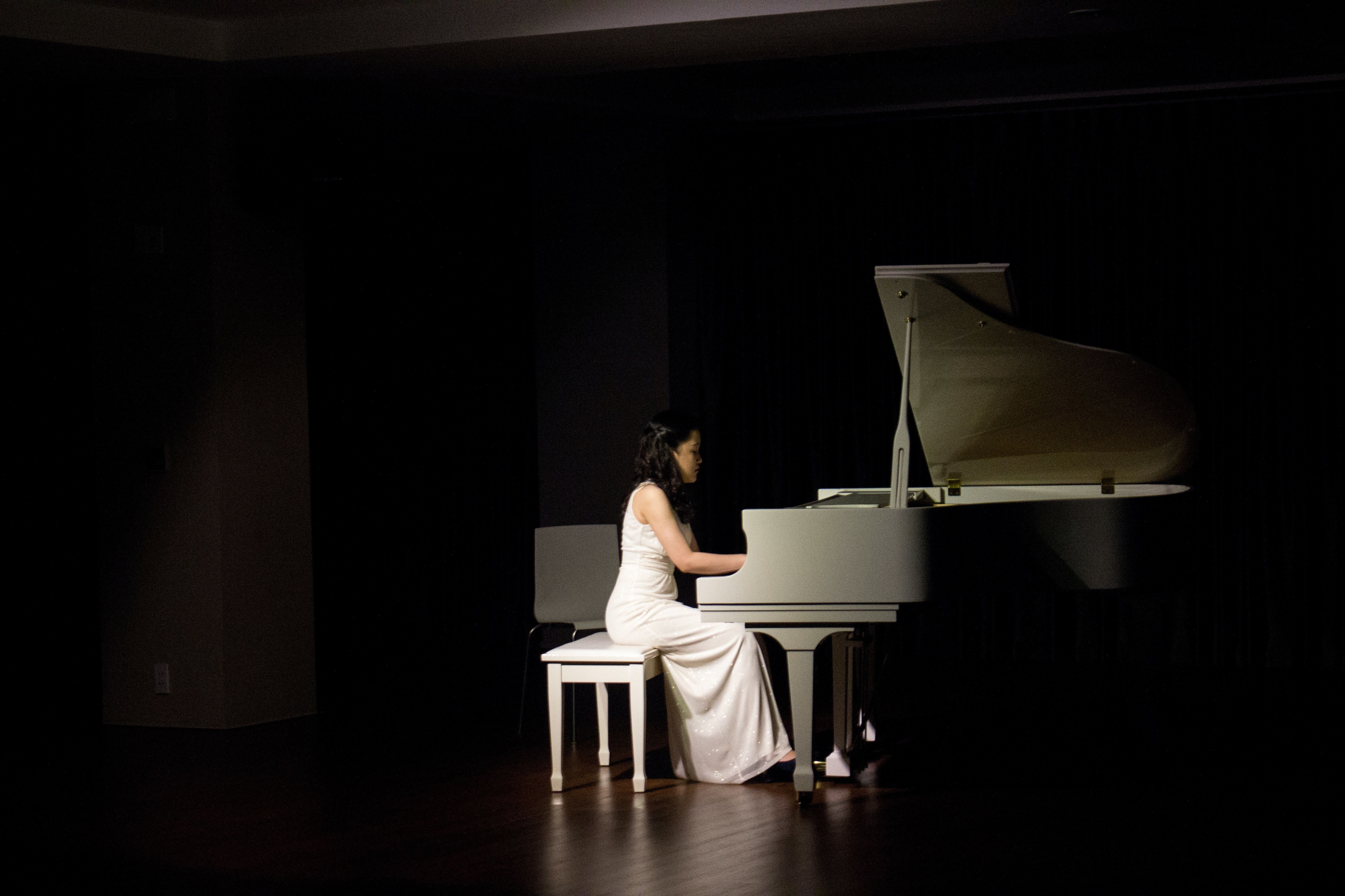 A woman in white dress playing the piano - Piano