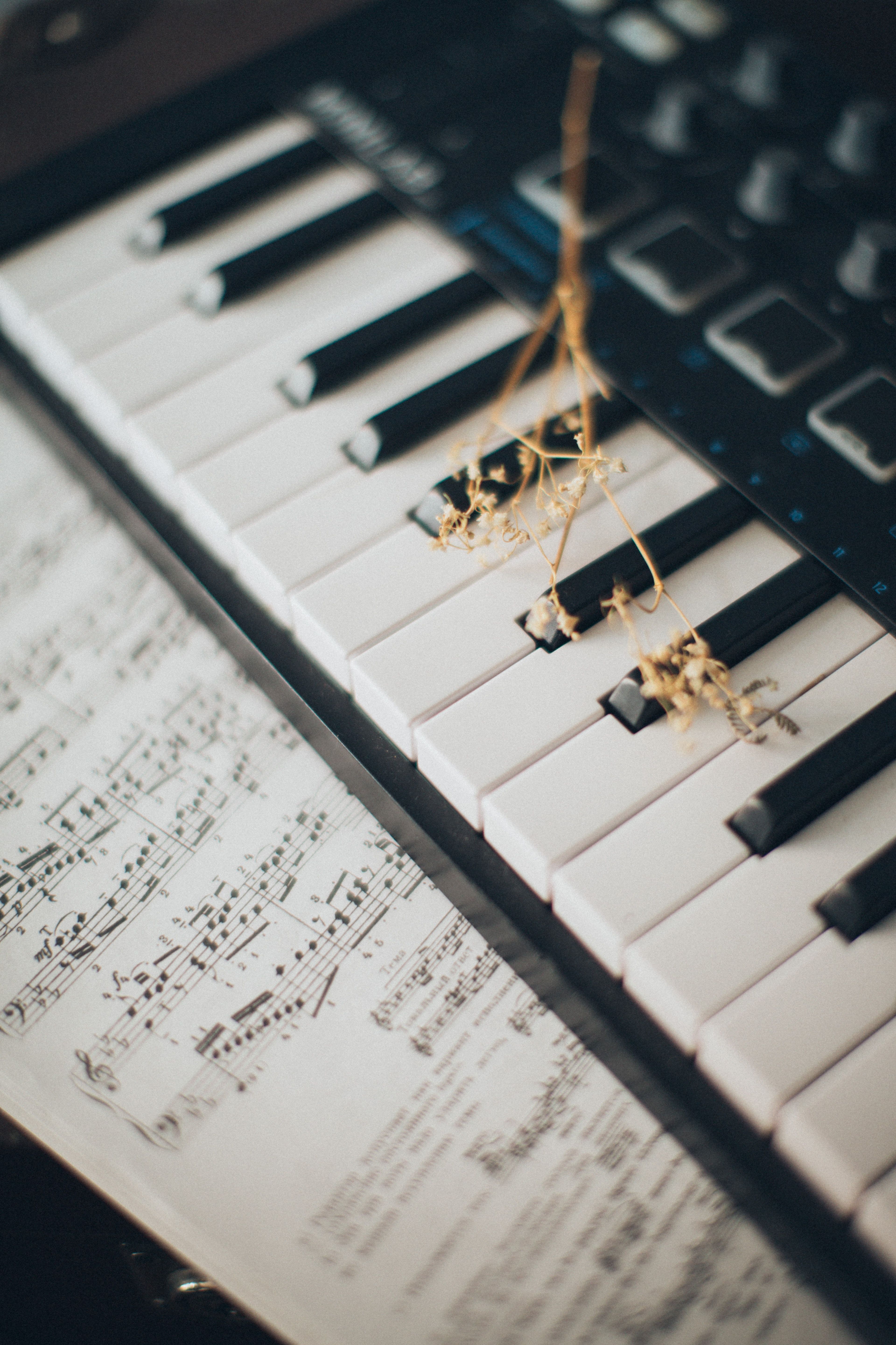 A keyboard is sitting on top of some sheet music - Piano