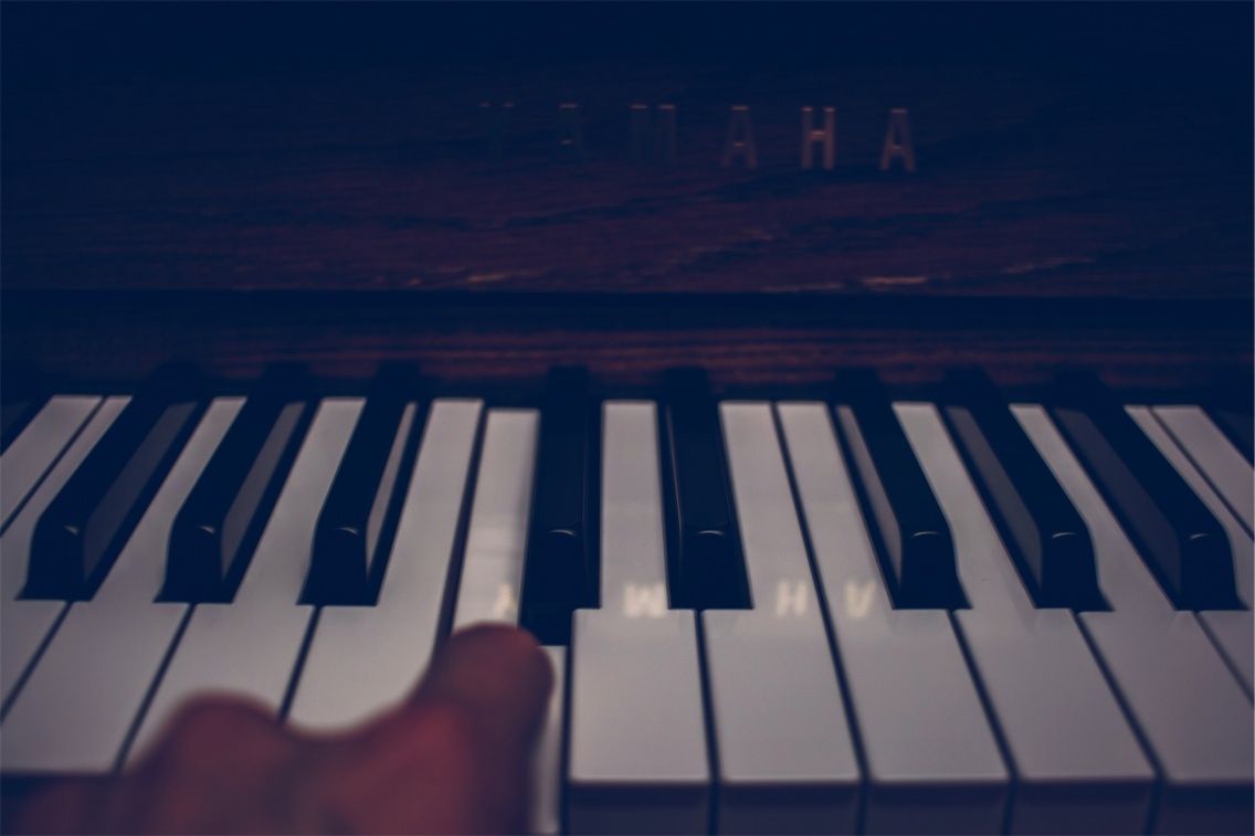 A hand is playing a piano. - Piano