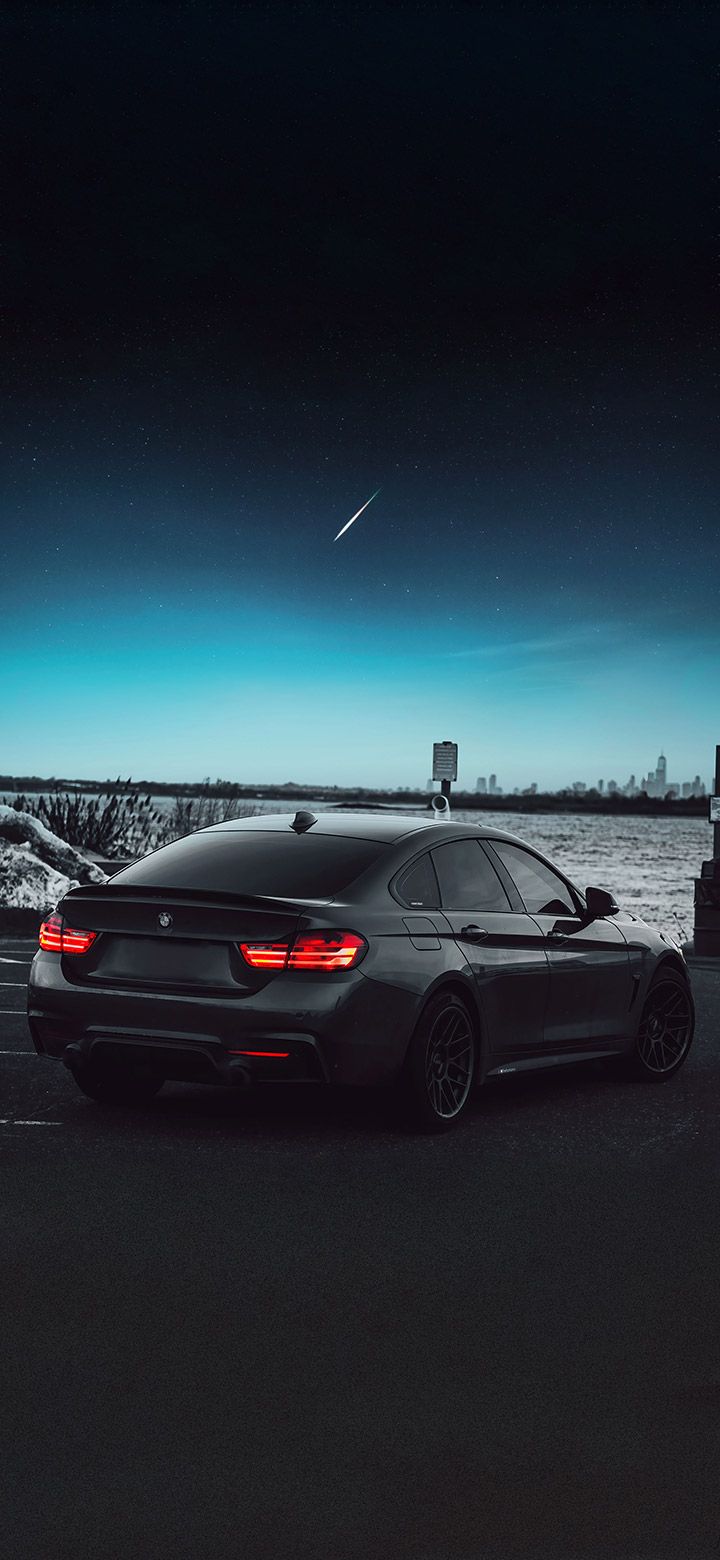 BMW car parked in a parking lot with a shooting star in the sky - BMW